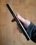 Hand holding a makeup product with 'Crystal Light Dream' text on a wooden surface