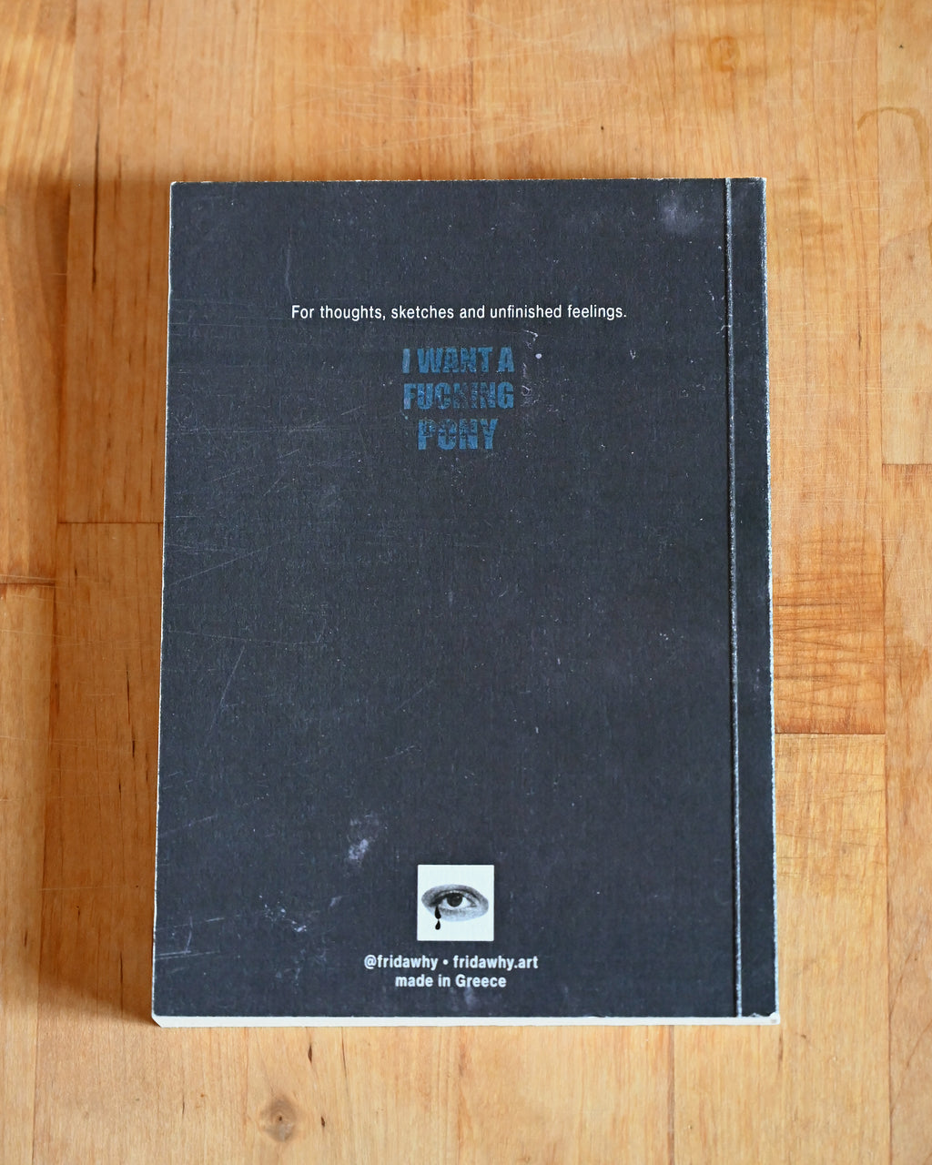 Black notebook with text on a wooden surface
