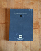 Blue notebook with text and a logo on a wooden surface