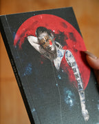 Book with a cover featuring an illustration of a person and a red moon on a blurred background