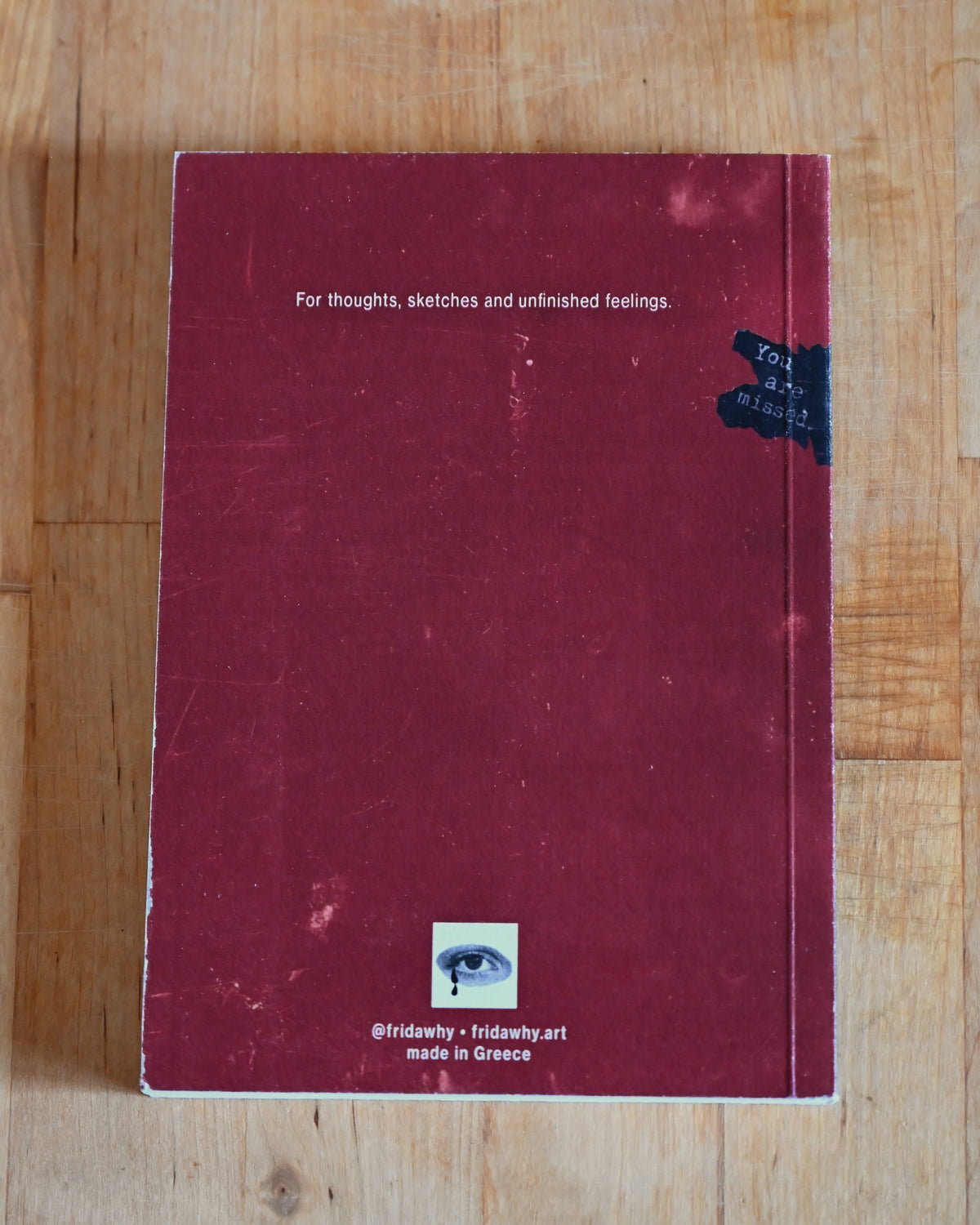 Red notebook with text on a wooden surface