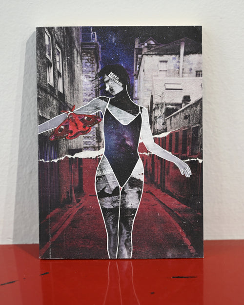 A rectangular art print or poster featuring a stylized collage of a woman in a black bodysuit standing in a red-lit alley, with torn-paper effects and a red abstract shape on the left, displayed against a light wall on a red surface.
